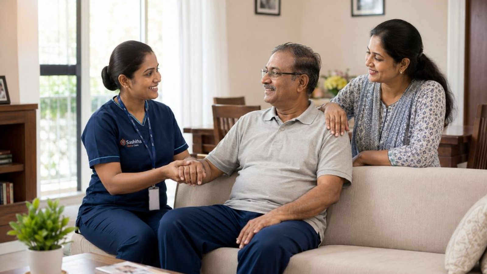 Home nurse supporting a stroke survivor at home in Chennai while a family member looks on